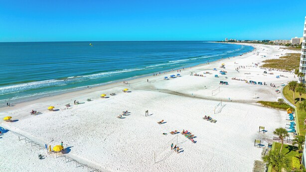 A beach with white sand, umbrellas, and a clear blue sky. - 2 Bedroom Condo at Crescent Arms Steps from the Beach! (Sarasota)