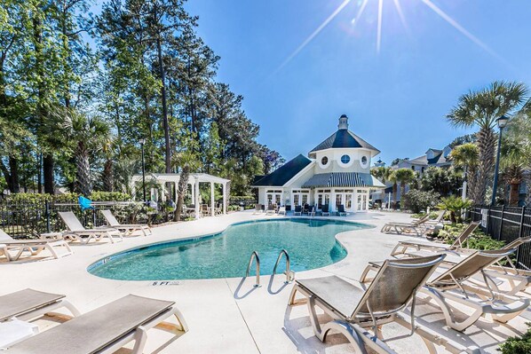 A pool area with lounge chairs and a gazebo, surrounded by trees. - My Vitamin Sea Quaint Studio Myrtle Beach SC (Myrtle Beach)