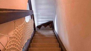 Een trap met een houten leuning en beklede treden.
