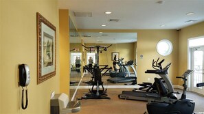 A hotel room with a mirror reflecting the gym area, a phone, and a window. - Modern Gray Studio Steps to Pool Myrtle Beach SC (Myrtle Beach)