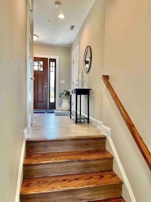 A staircase with wooden steps and a white handrail, leading to a door with a glass panel. - South River Waterfront | Pier, Hot Tub & Elevator (Edgewater)
