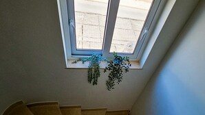 A staircase leading to a room with a skylight and hanging plants. - FLH Quinta das Salinas Triplex with Terrace & Pool (Vale do Lobo)
