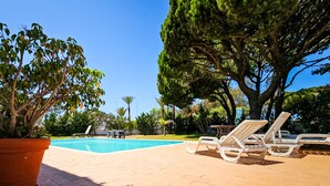 A pool area with lounge chairs and a potted plant. - FLH Quinta das Salinas Triplex with Terrace & Pool (Vale do Lobo)