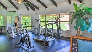 A gym with various exercise equipment, large windows, and a ceiling fan. - Chic Gulf Breeze Escape w/ Pool Access & Courtyard (Gulf Breeze)