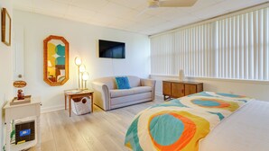 A bedroom with a bed, a sofa, a TV, and a ceiling fan. - Chic Gulf Breeze Escape w/ Pool Access & Courtyard (Gulf Breeze)