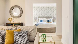Un dormitorio moderno con una cama, una mesita de noche, un espejo y vistas a otra habitación.