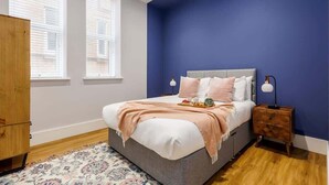 A bedroom with a bed, bedside table, and a nightstand.