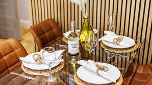 A dining table set with white plates, gold napkin rings, and a bottle of Casillero del Diablo wine. - Stunning & Spacious 1-Bed Apt w/ Free Gym & PKG (Bournemouth)