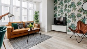 A living room with a sofa, coffee table, and a TV stand.