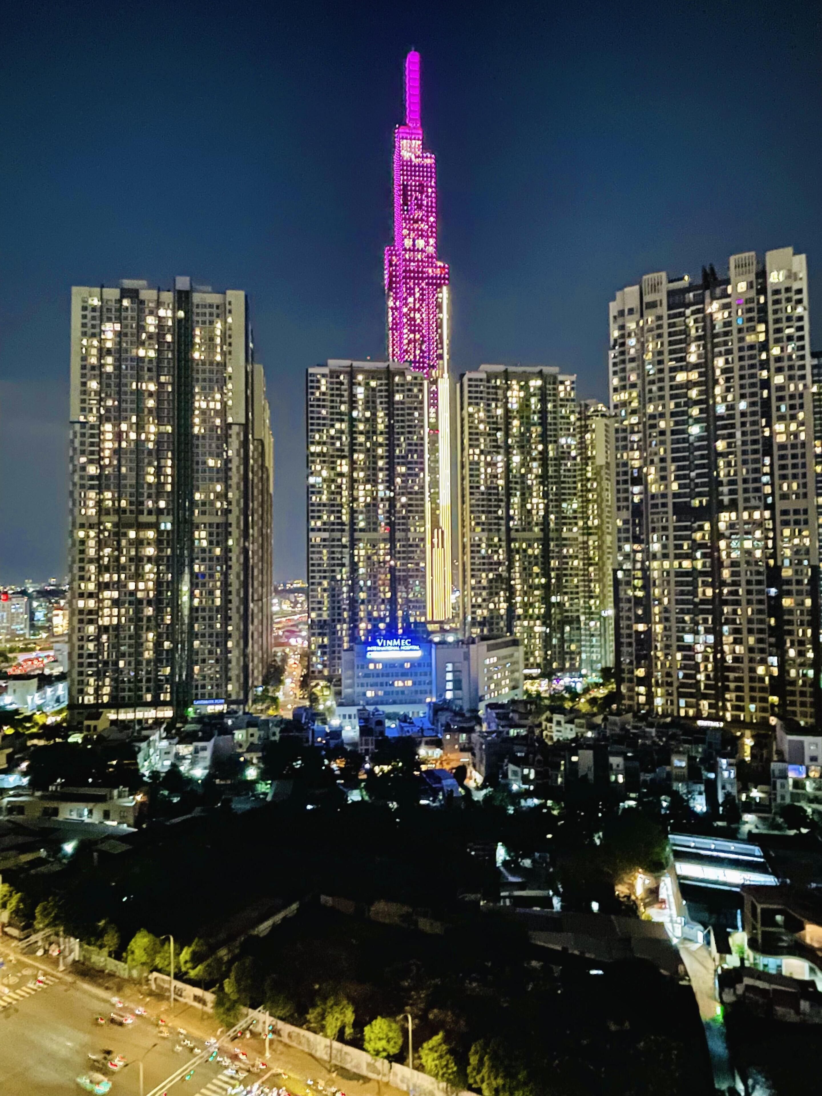 A high-rise building with illuminated windows and a prominent vertical structure.