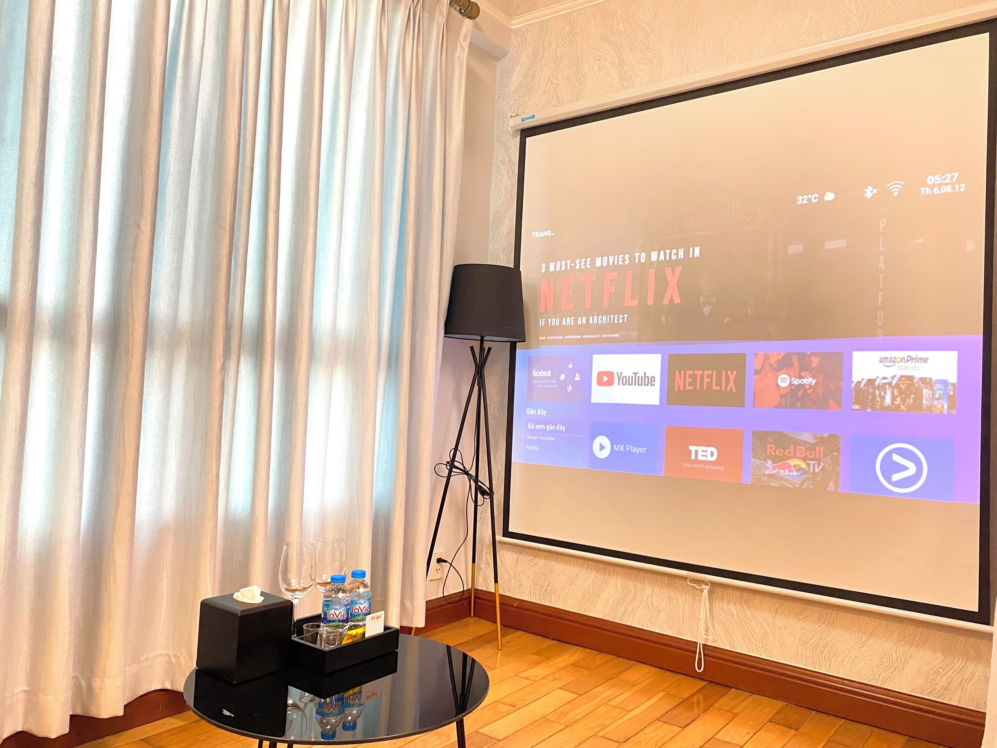 A projection screen displaying a Netflix interface with various streaming service logos.