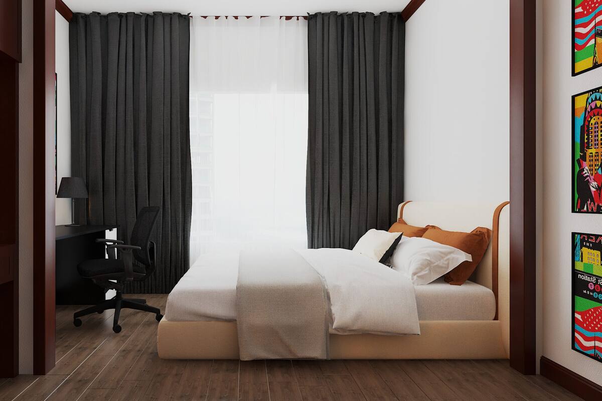 A hotel room with a bed, a desk, a chair, and a window with curtains.