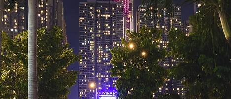 A night view of a cityscape with a prominent building lit in pink and blue.