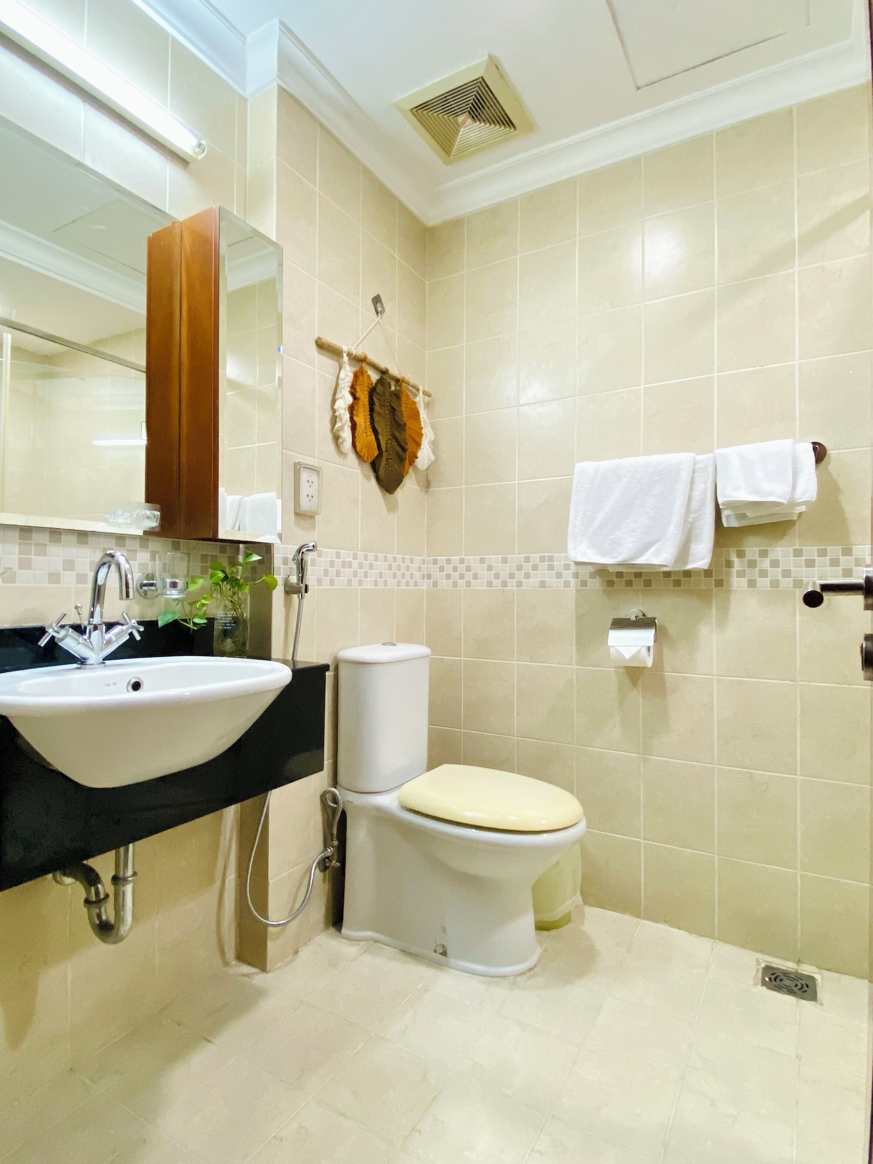 A bathroom with a sink, toilet, and mirror.