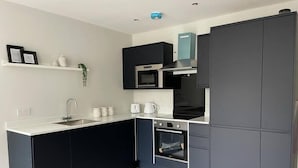 A modern kitchen with a built-in oven, a microwave, and a sink. - NEW & Vibrant 1-Bed in Town Centre w/ Free Parking (Bournemouth)