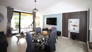 Un comedor con una mesa, sillas y un televisor.