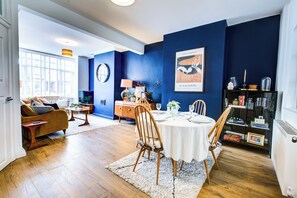 Un coin repas avec une table ronde, des chaises et un mur d’accent bleu.