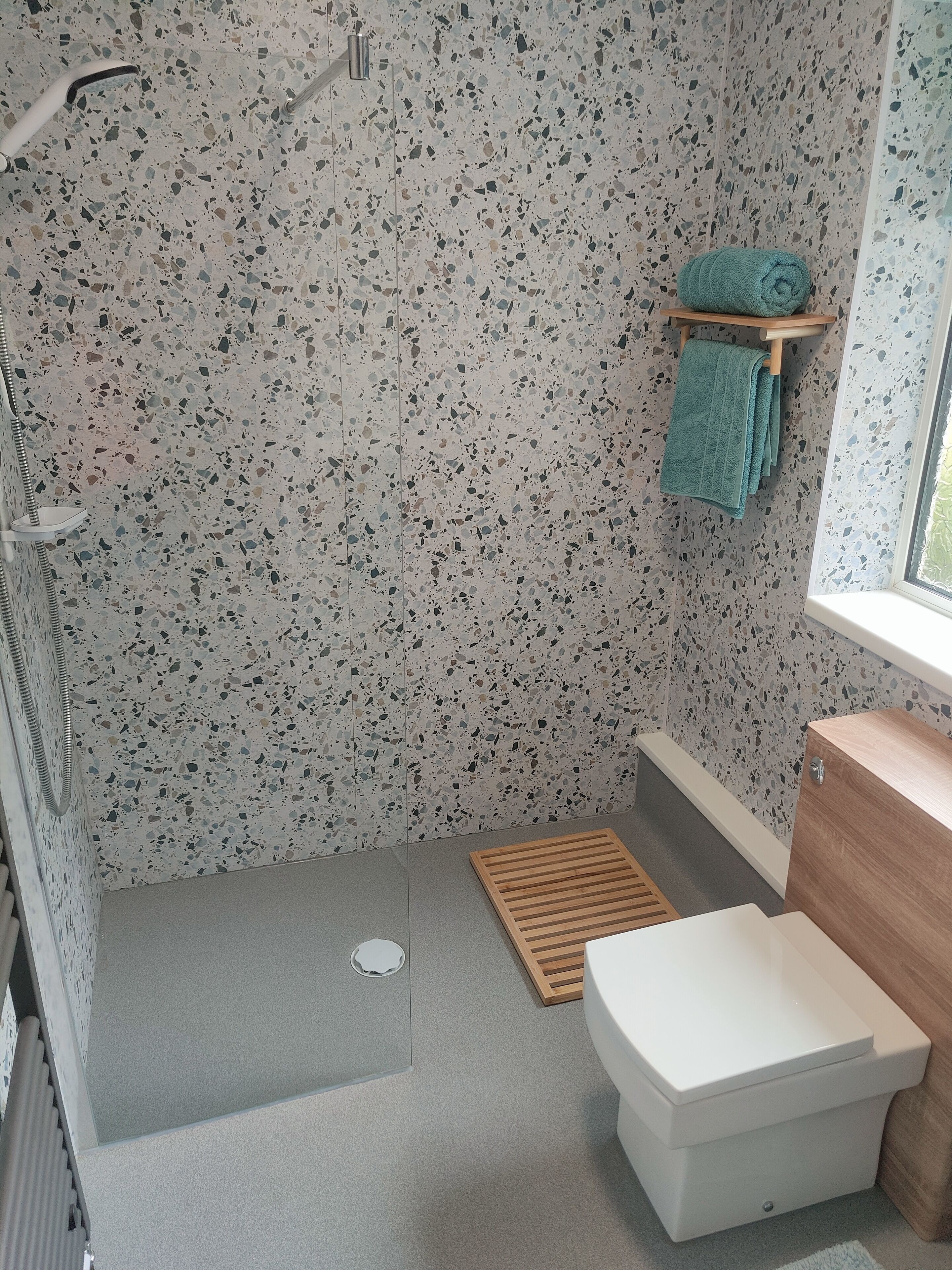 A bathroom with a shower, a toilet, and a sink.