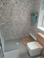 A bathroom with a shower, a toilet, and a sink.