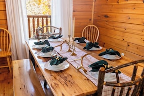 A wooden dining table set for a meal with white plates, green napkins, and gold candelabras. - 3 Min to Parkway | Private Resort Pool | Top 5%! (Pigeon Forge)