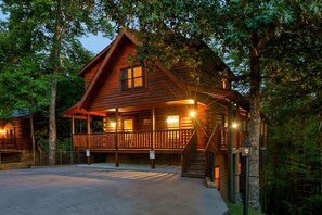 A wooden cabin with a porch, surrounded by trees. - 3 Min to Parkway | Private Resort Pool | Top 5%! (Pigeon Forge)