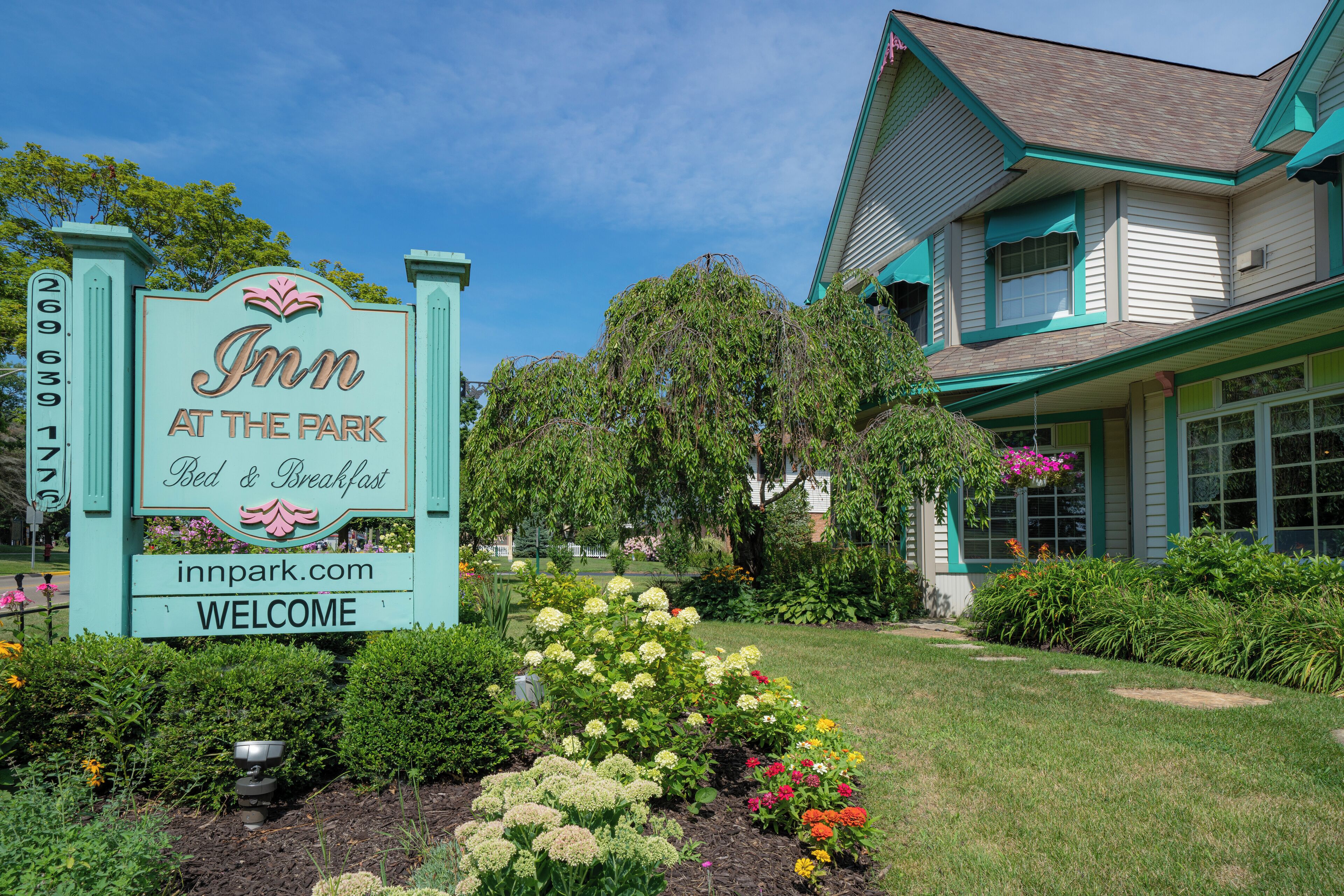 A sign for 'Inn at the Park' with a garden in front.