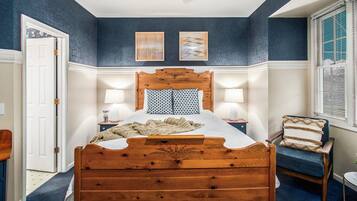 A bedroom with a wooden bed, two wall-mounted lamps, a ceiling fan, and a window with blinds.
