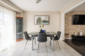 A modern dining area with a table, chairs, and a painting on the wall. - GLOBALSTAY Modern 3BR house in Newmarket (East Gwillimbury)