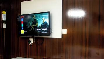 A wall-mounted TV with a white entertainment unit below it.