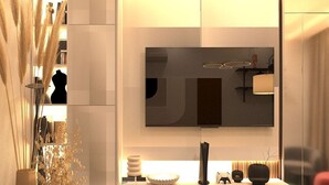 Una sala moderna con un televisor de pantalla plana grande montado en la pared, un mueble bajo blanco con objetos decorativos y altas pampas decorativas.