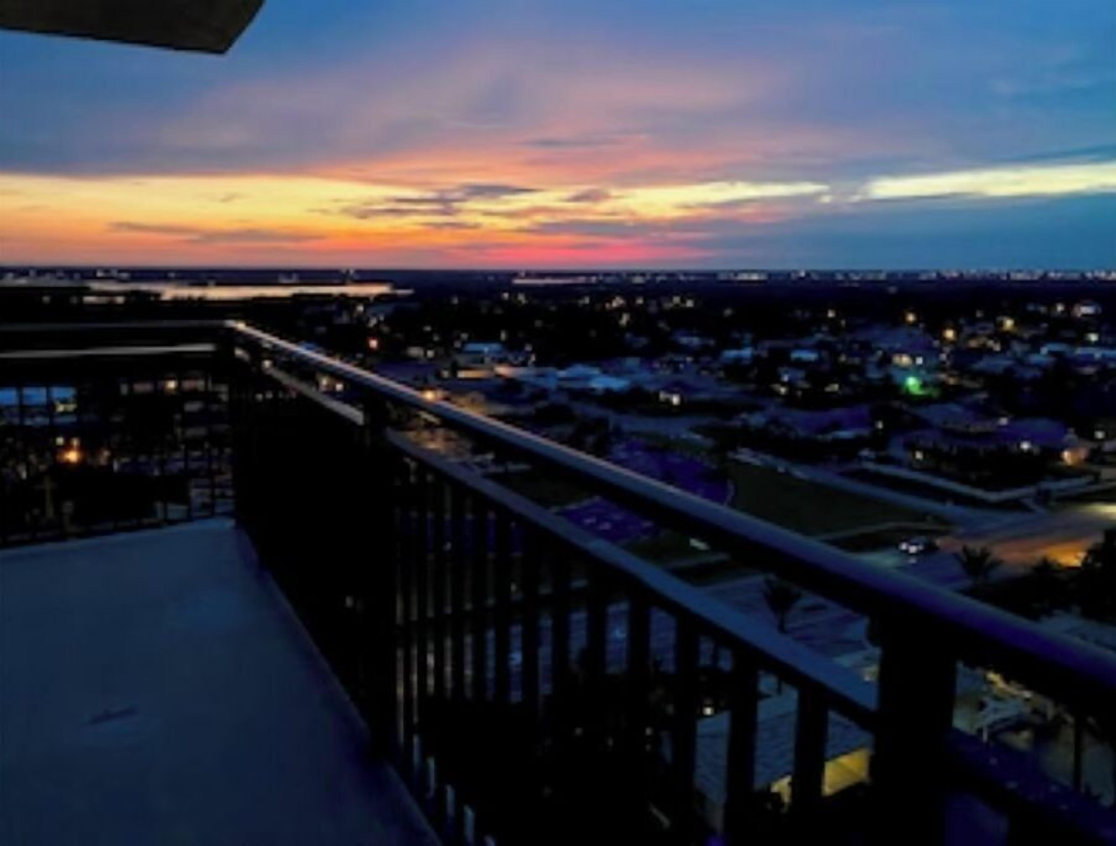 Un balcón con vistas a un paisaje urbano al anochecer.