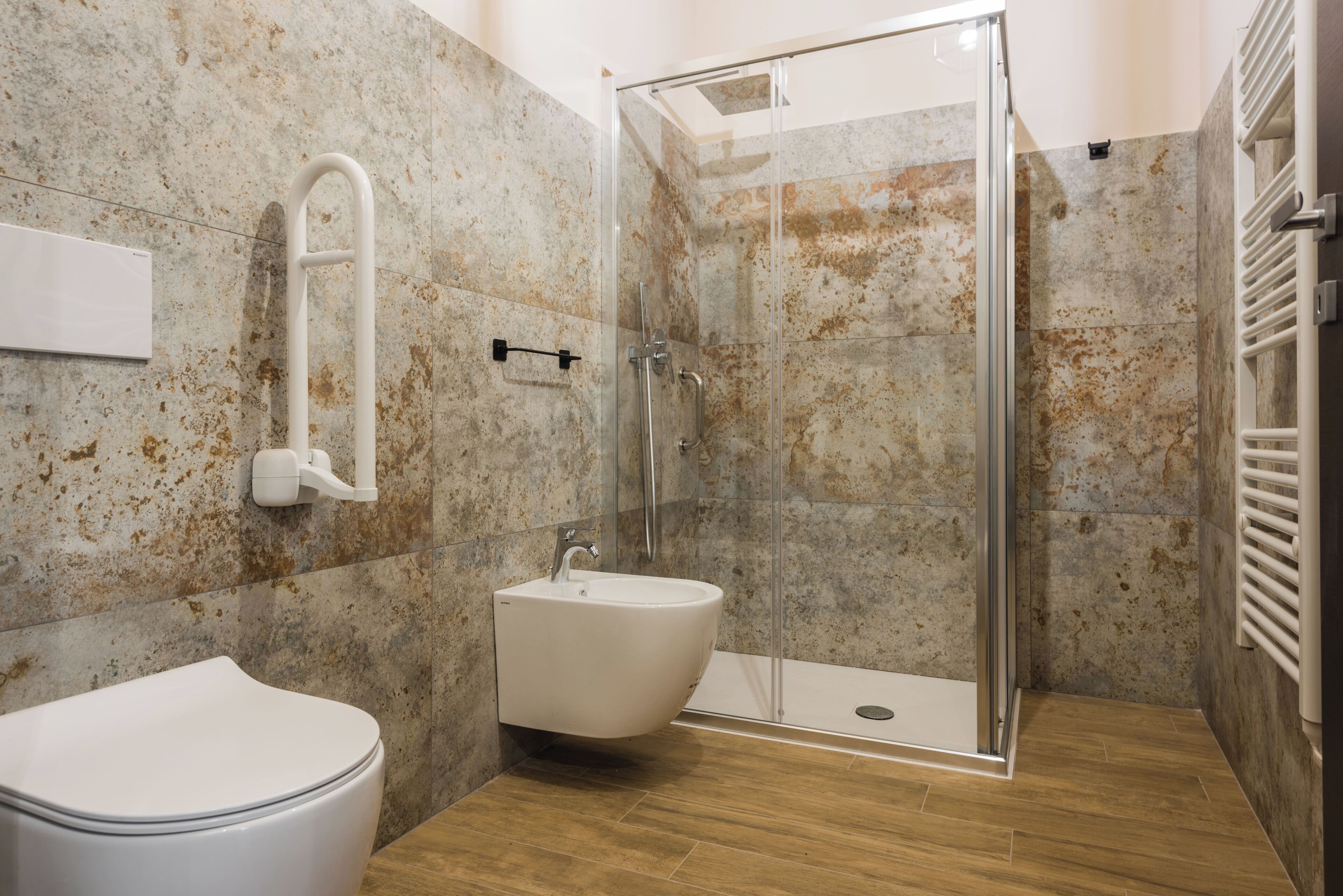 Un baño moderno con ducha de vidrio, lavamanos blanco y retrete.