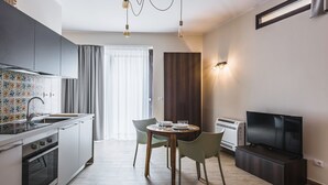 A modern kitchen with a dining area, a flat-screen TV, and a built-in air conditioner. - Venuto Homes by Wonderful Italy (Catania)