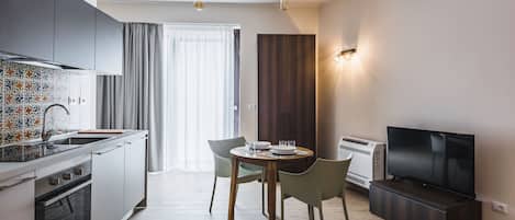 A modern kitchen with a dining area, a flat-screen TV, and a built-in air conditioner.