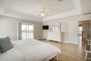 Relax in this serene bedroom with a large bed, ceiling fan, and flat-screen TV.