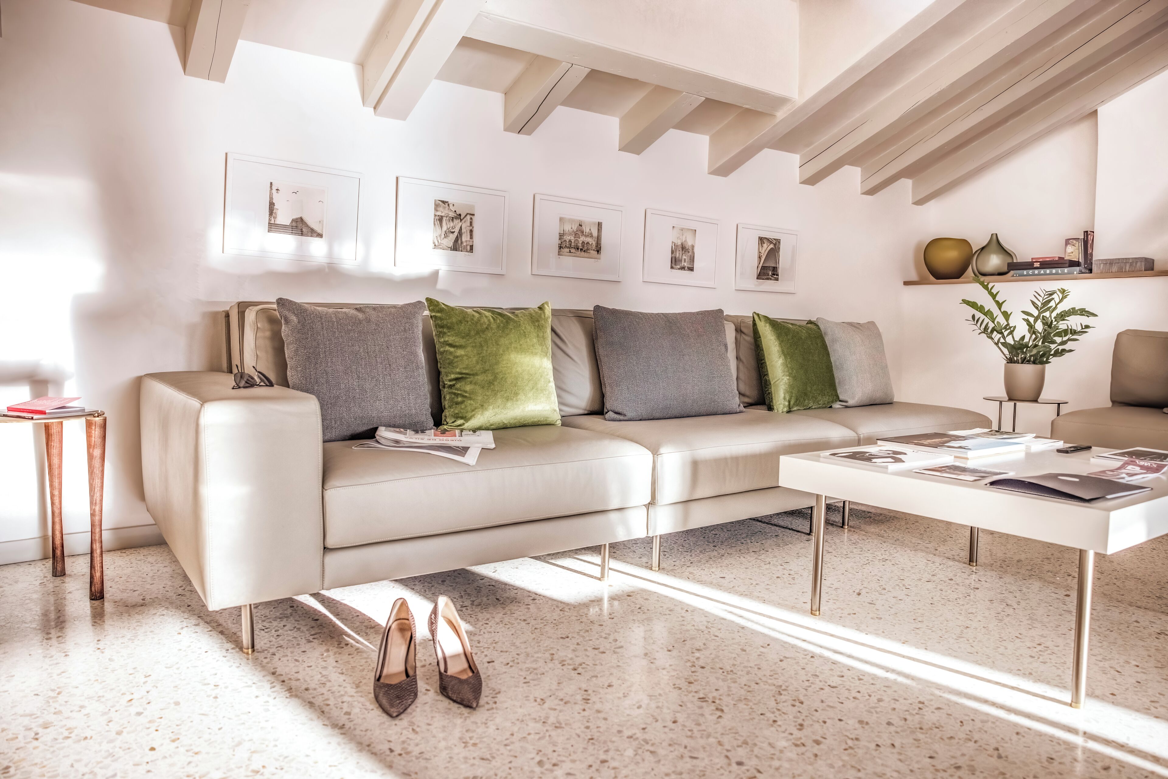 A modern living room with a sofa, coffee table, and framed pictures on the wall.