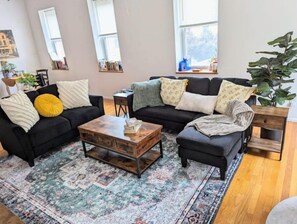 Relax in a cozy living space with a comfortable sofa, coffee table, and potted plant.