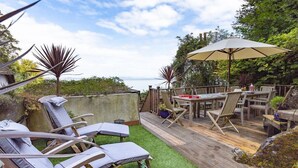 A deck with outdoor furniture, a table, and an umbrella. - 5 Bed - Rose Cottage (Torquay)