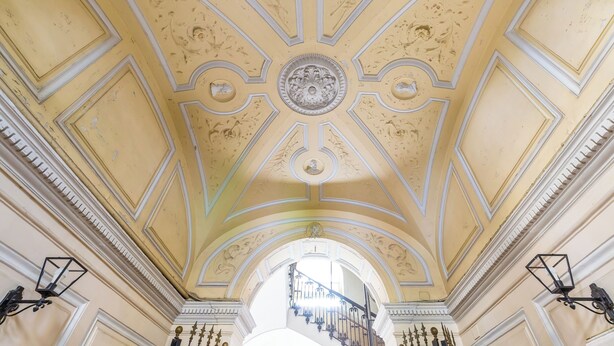 A grand hall with a high ceiling featuring intricate moldings and a central decorative element. - Attico al Duomo by Napoliapartments (Naples)