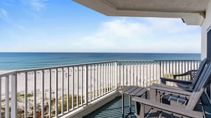 A balcony with a view of the beach and ocean.