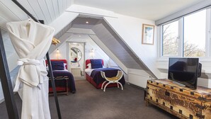 A bedroom with a loft bed, a television on a wooden dresser, and a window with a view. - 3 Bed Cove Cottage (Torquay)