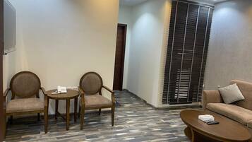 A hotel lobby with a sofa, two armchairs, a coffee table, and a telephone.