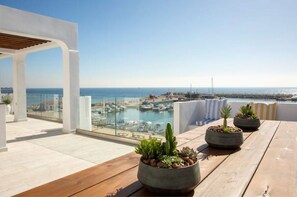 Eine Dachterrasse mit Blick auf einen Hafen und das Meer.