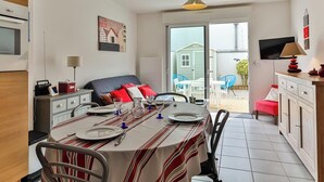 Un espacio habitable compacto con comedor, kitchenette y vistas al exterior.