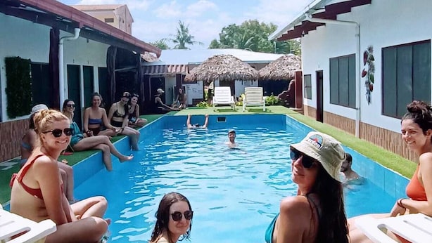 A swimming pool area with lounge chairs and a thatched-roof structure. - EL CURICHAL HOSTEL (Rurrenabaque)