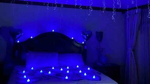 A bedroom with a bed, a ceiling fan, and blue lighting. - Villa Paradise- Pool, Jacuzzi & More (Montego Bay)