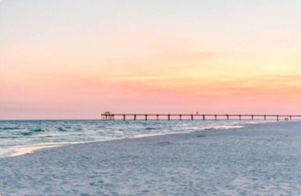 Enjoy a serene coastal scene with a pier stretching into the sea, perfect for a peaceful stroll.