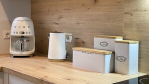 Eine Küche mit Kaffeemaschine, Wasserkocher und zwei Aufbewahrungsboxen für Kaffee.