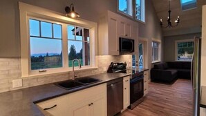 A kitchen with a large window, a built-in oven, and a dishwasher. - The Nest!! (Lantzville)
