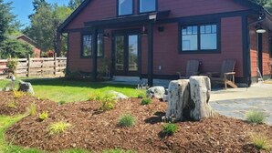 A red house with a large window and a porch. - The Nest!! (Lantzville)